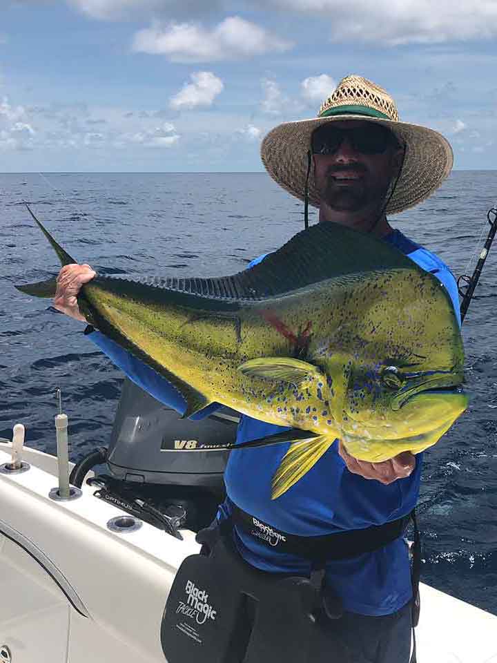 man holding mahi mahi dolphin fish charter boat of Paradise Outfitters in Venice LA