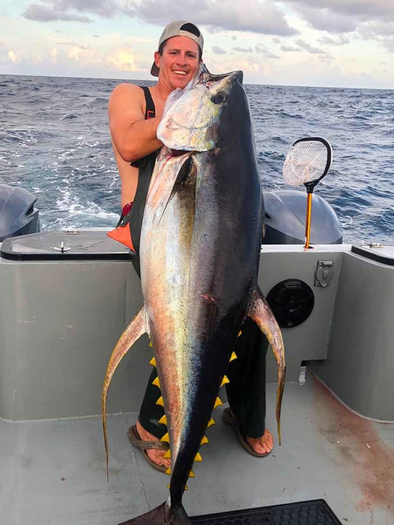 male holding a giant yellowfin tuna on a Tuna Charter fishing trip in Venice Louisiana