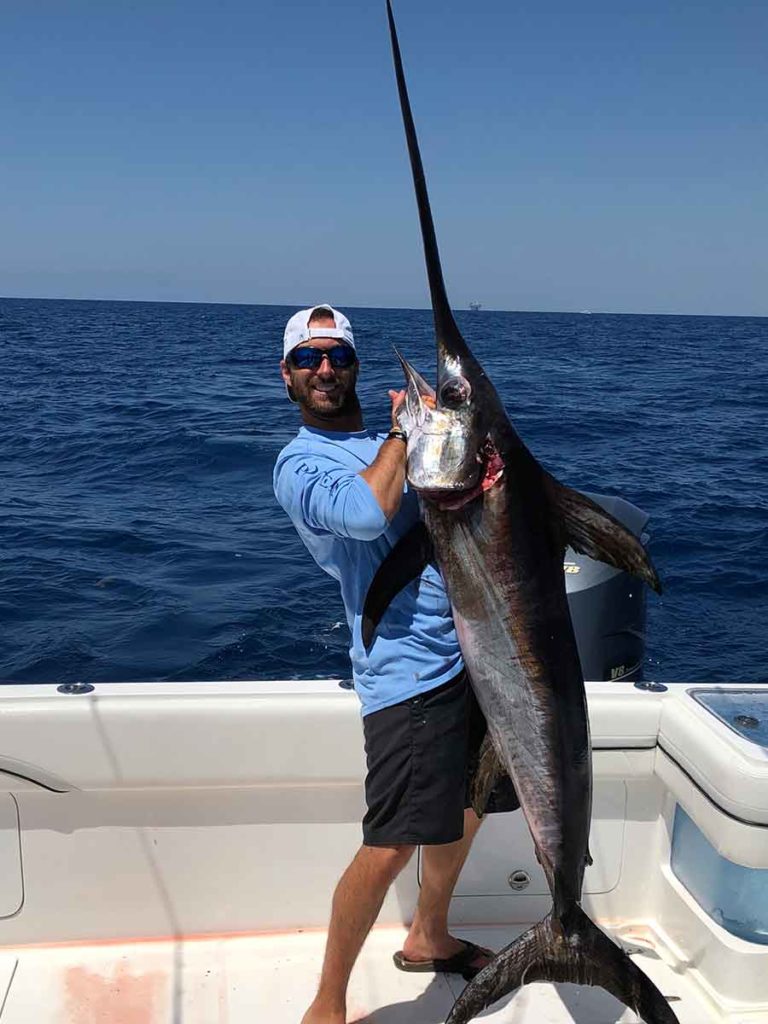 man holding swordfish that he caught in the gulf of Mexico off the Louisiana coast
